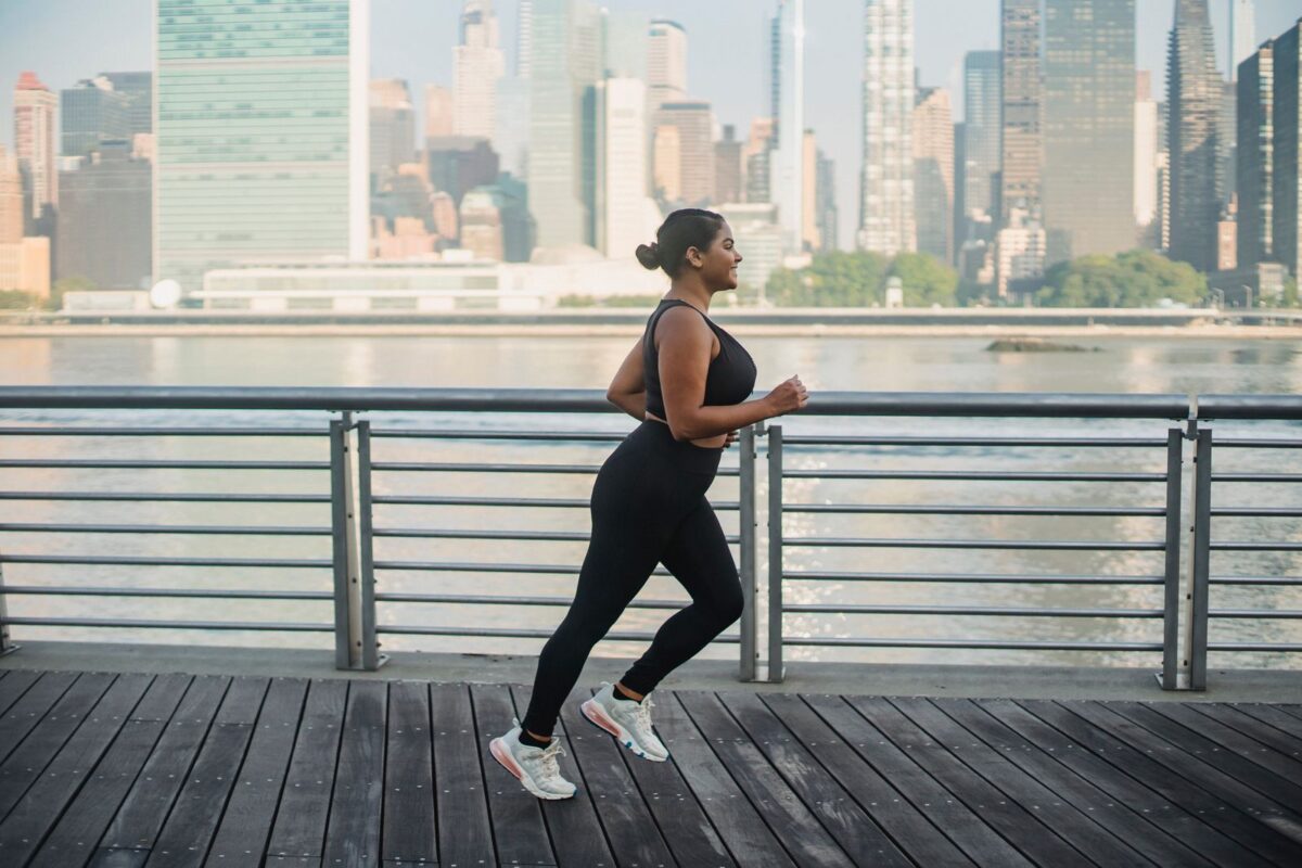 Une femme en train de courir sur une promenade urbaine